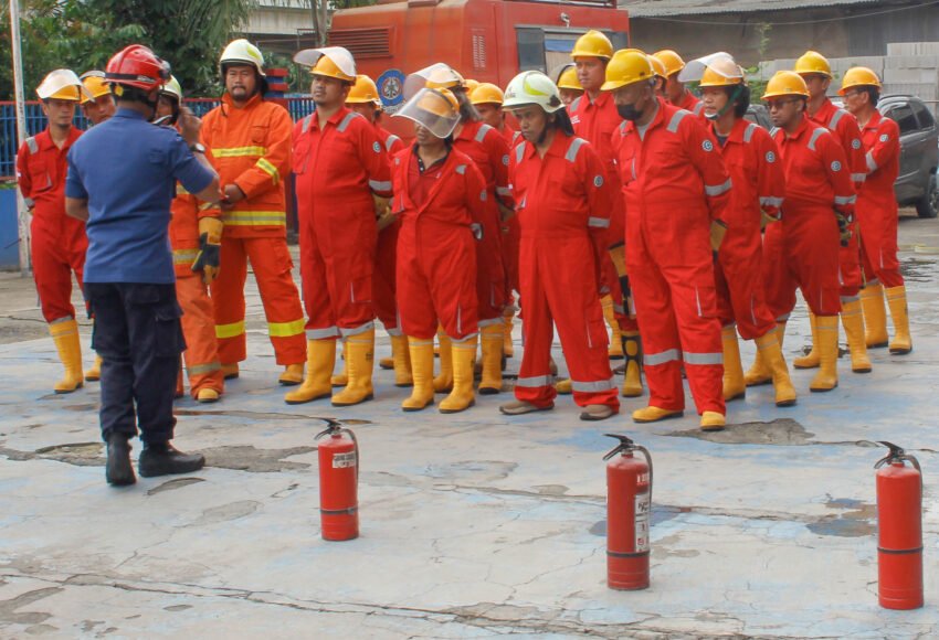 Latihan pemadam kebakaran, fokus dan tertib, mencerminkan kesiapan menghadapi bahaya.